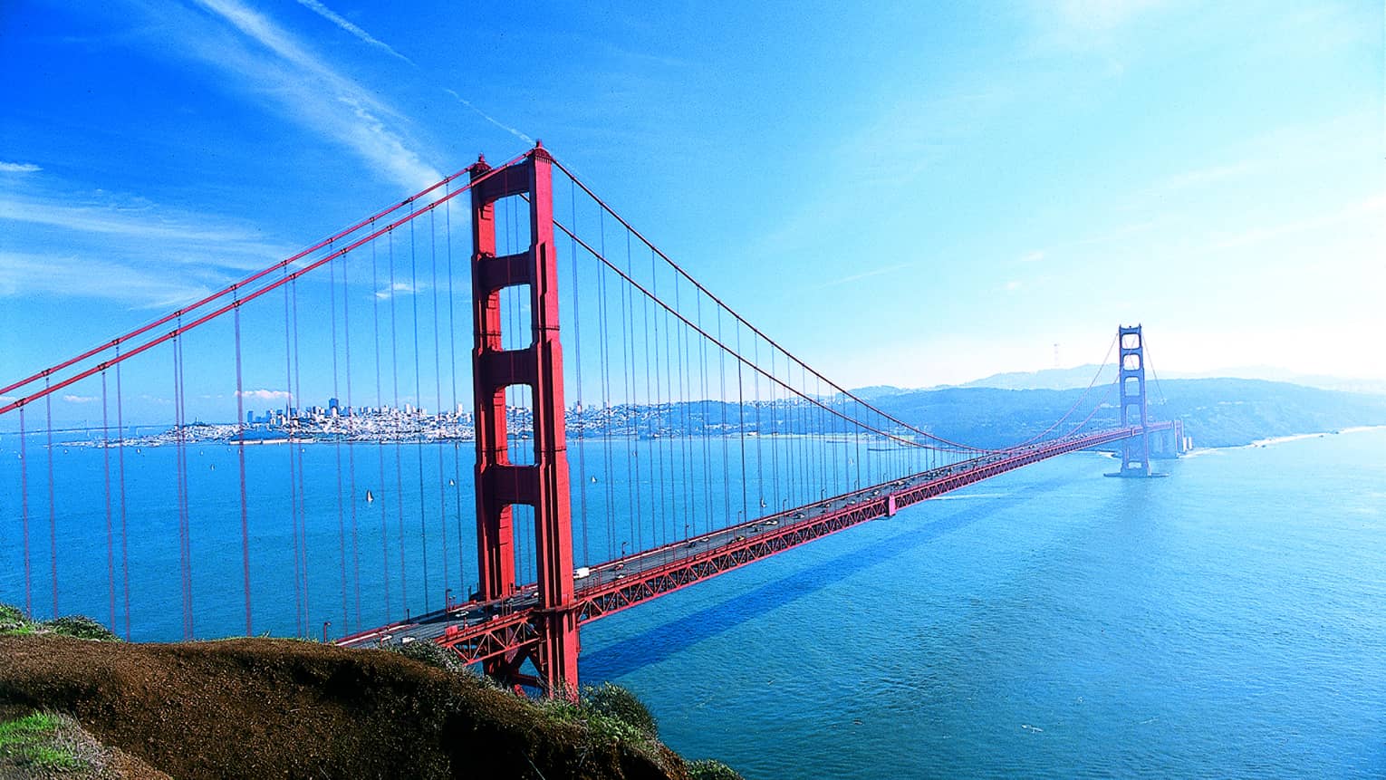 A large red metal bridge crossing water.