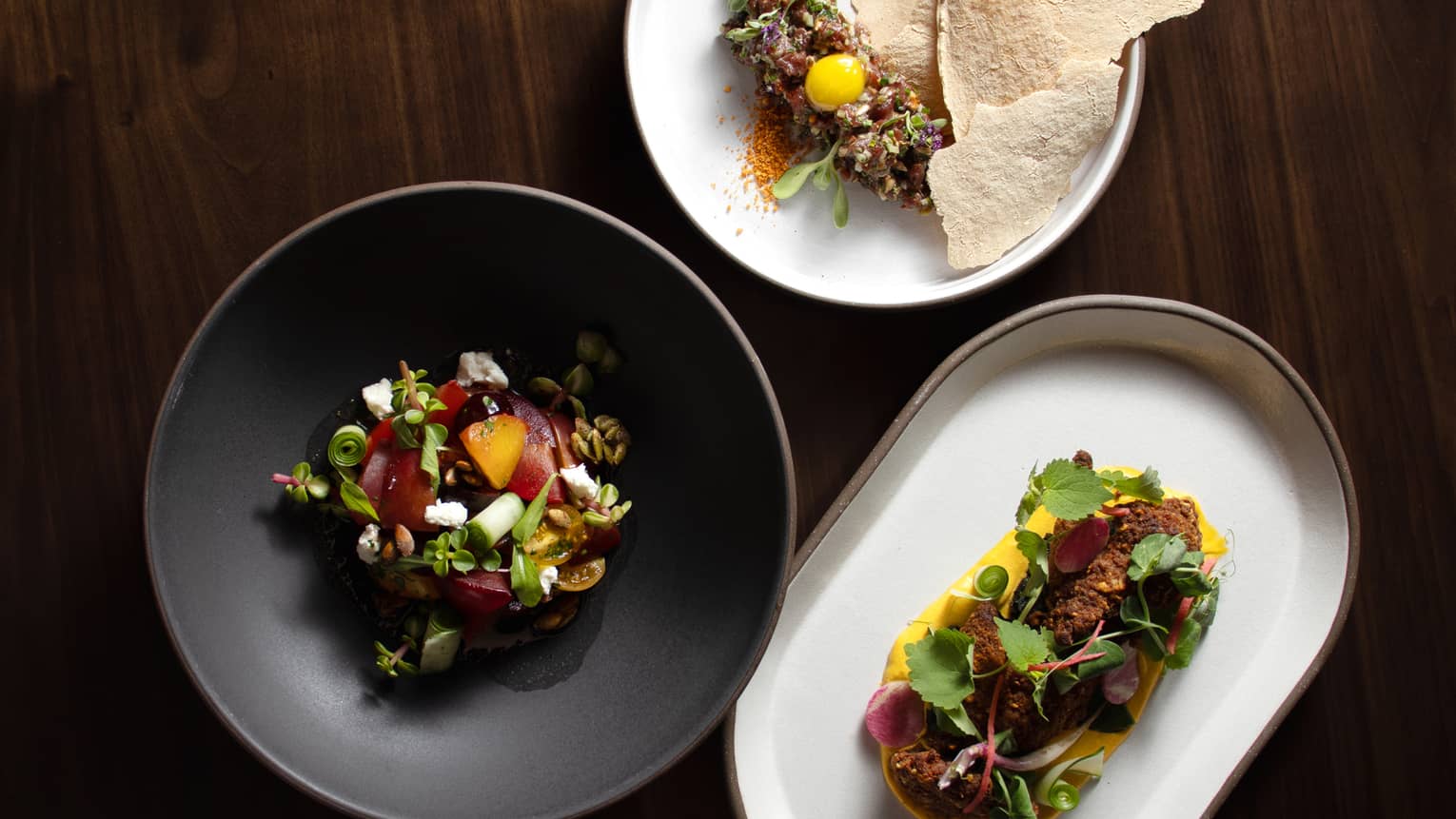 Three colourful dishes topped with fresh ingredients