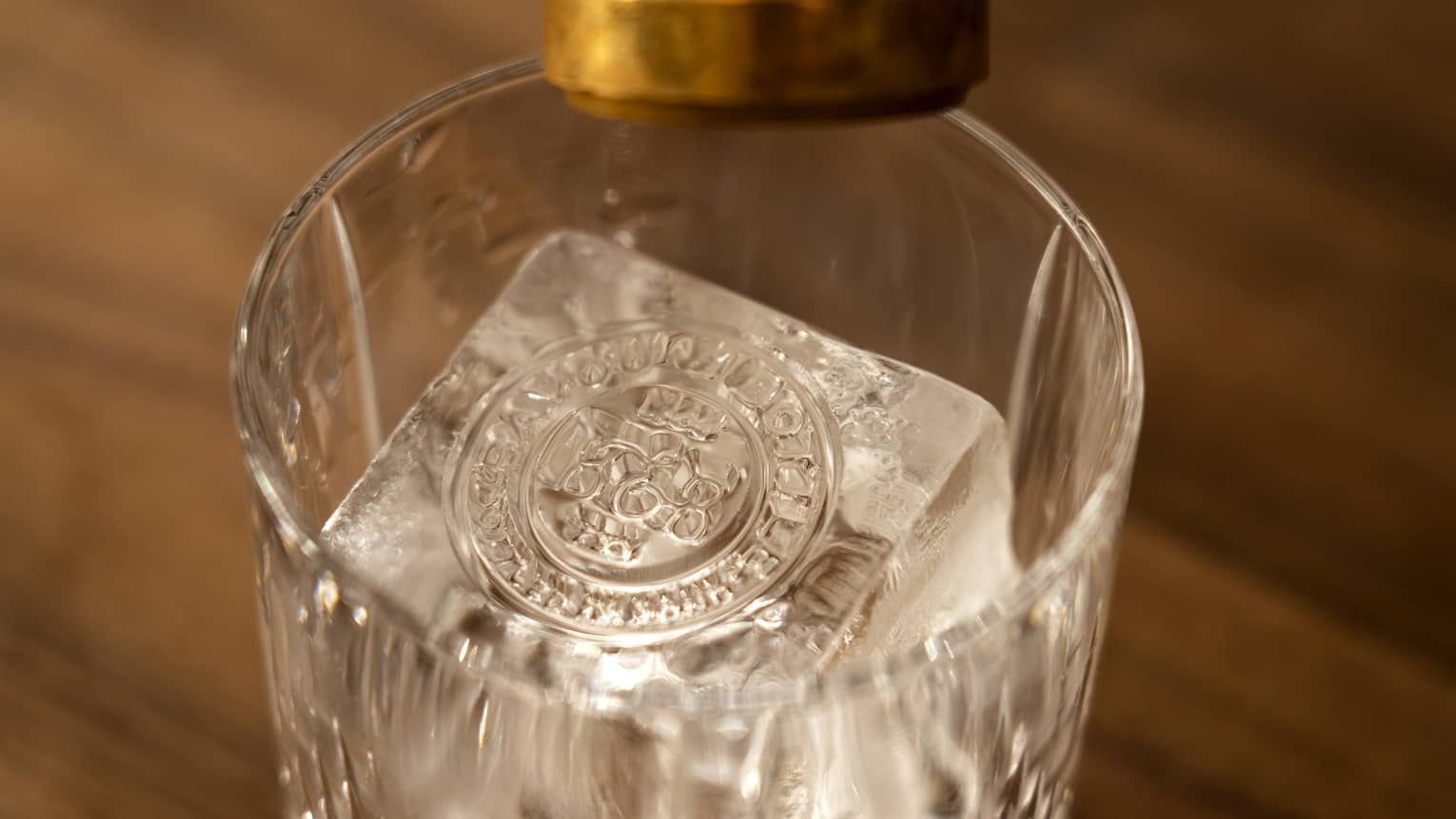 A glass with a cube of ice that has been stamped.