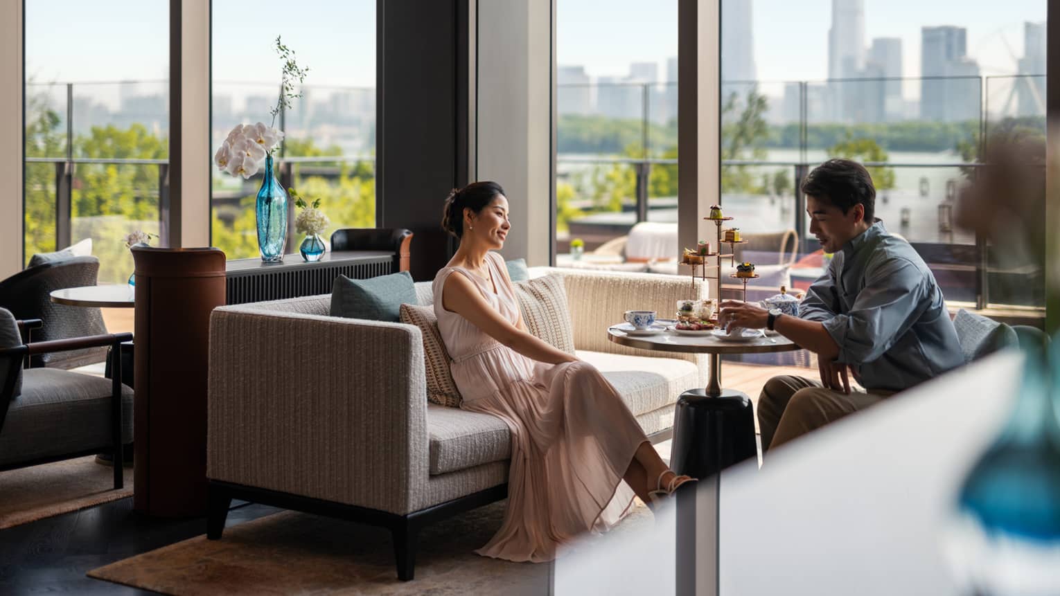 Man and woman enjoy afternoon tea at Lobby Lounge at luxury hotel