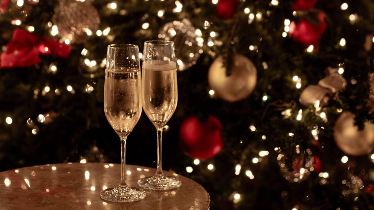 Joyous champagne toast with festive lights for Tokyo Christmas and New Year’s Eve celebrations.