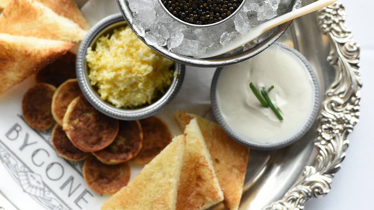 Appetizer platter with caviar and cucumbers on ice, cheeses and meats