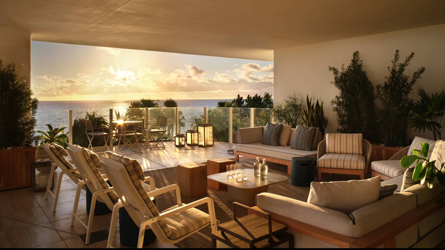 Covered suite terrace furnished with lounge seating that overlooks the ocean