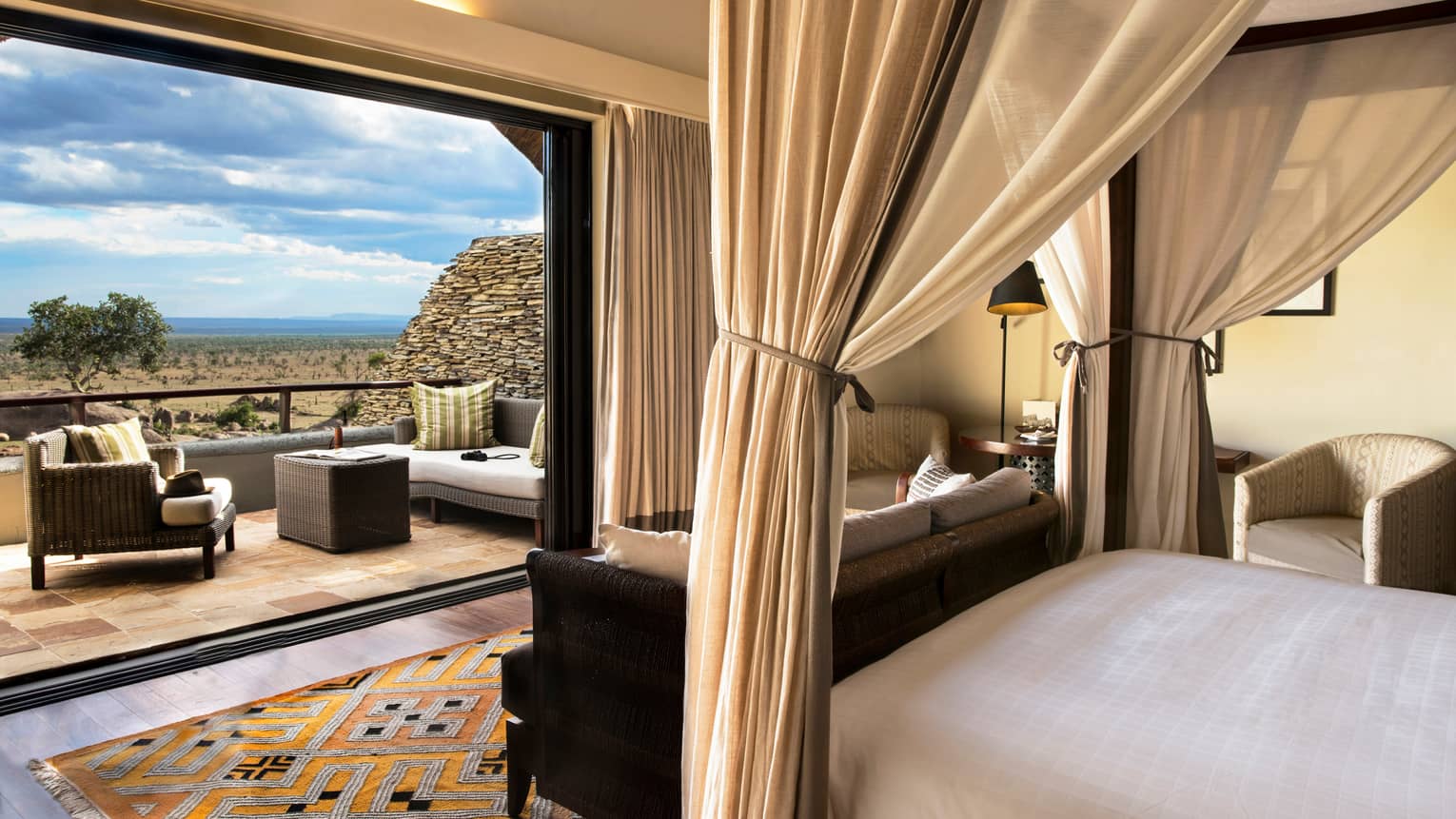 Horizon room from the perspective of a poster bed. Includes a tied canopy, colourful carpet, open patio wall