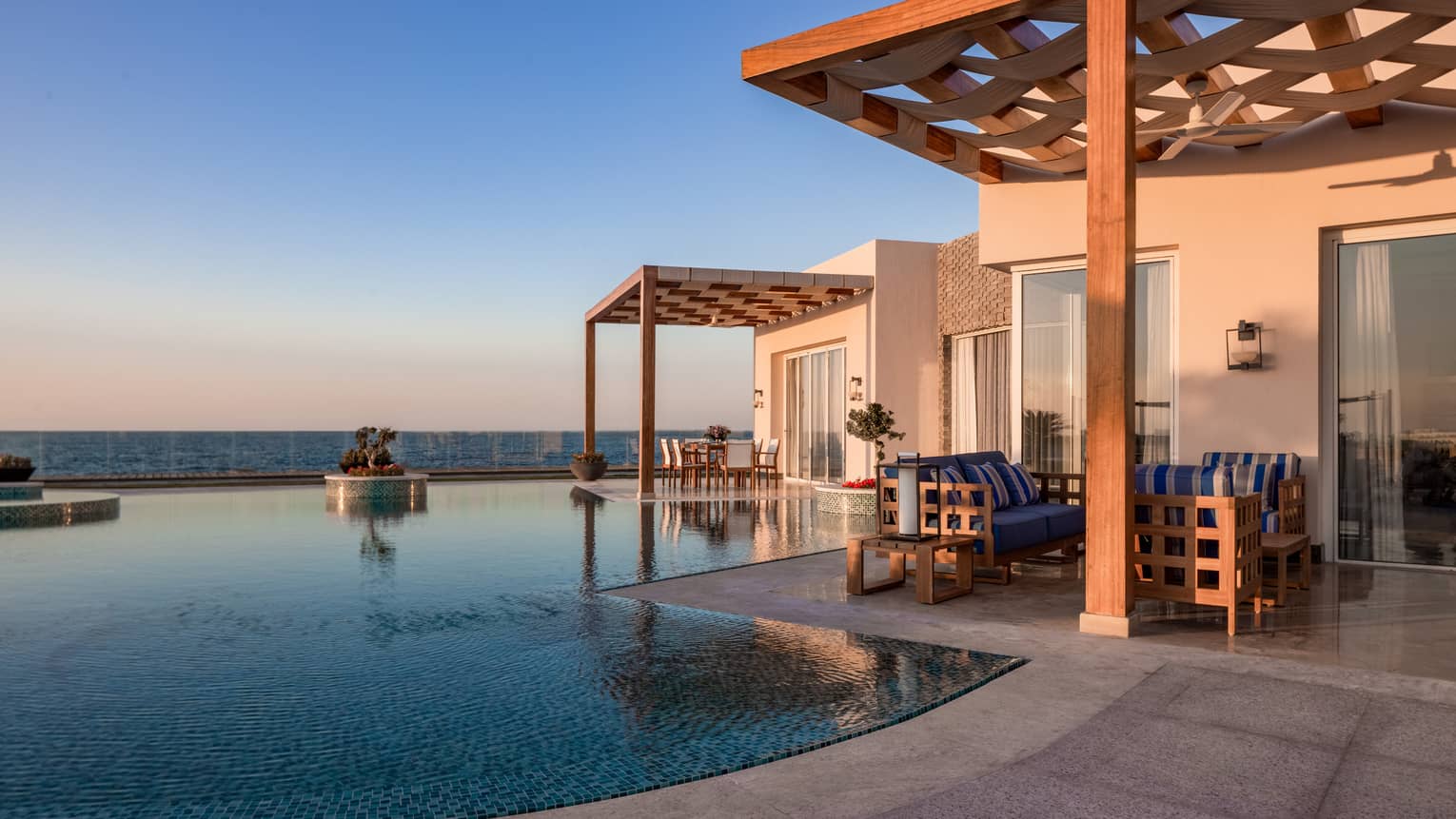 Pool and covered patio of The Palace at sunset