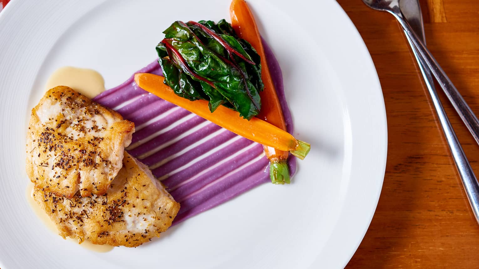 Slow-roasted Tempeh, streaks of purple sauce, whole carrots, kale