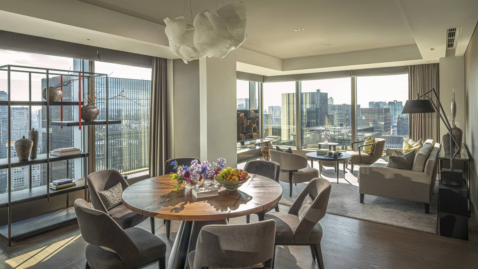 A modern living and dining room area with a city view