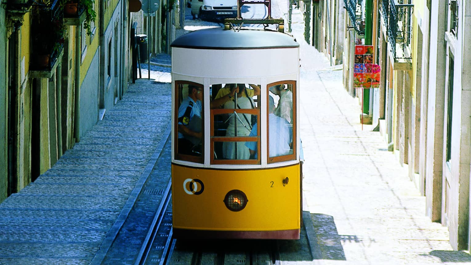 People pack yellow trolley sidecar on Lisbon city street