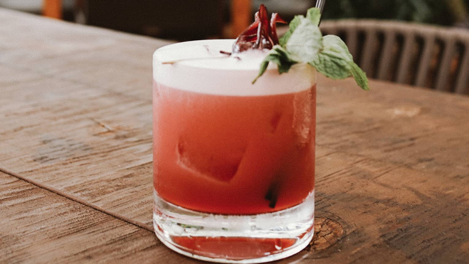 Fruity cocktail with mint garnish on patio table