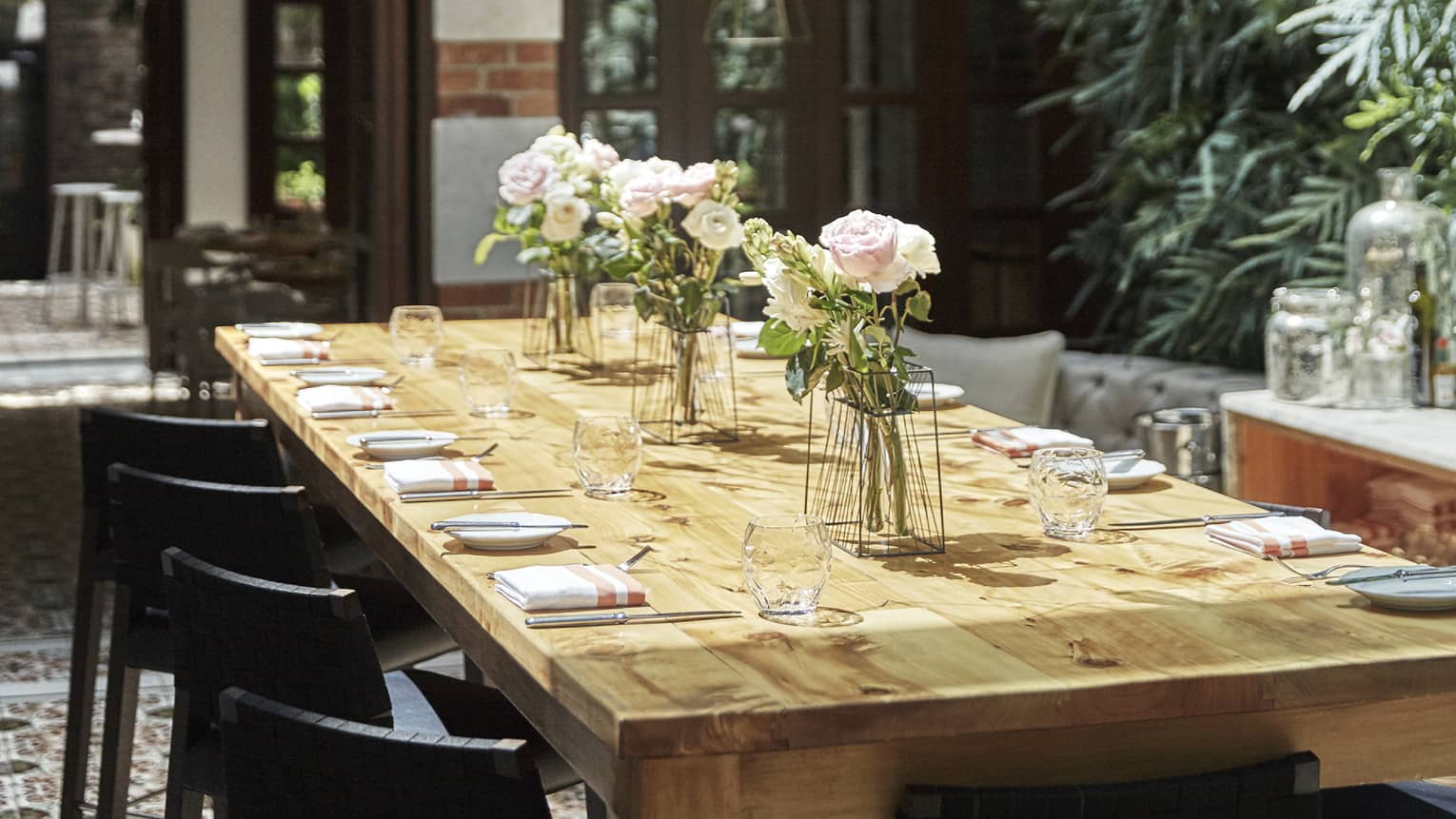 A wooden dining table under a series of Edison bulbs
