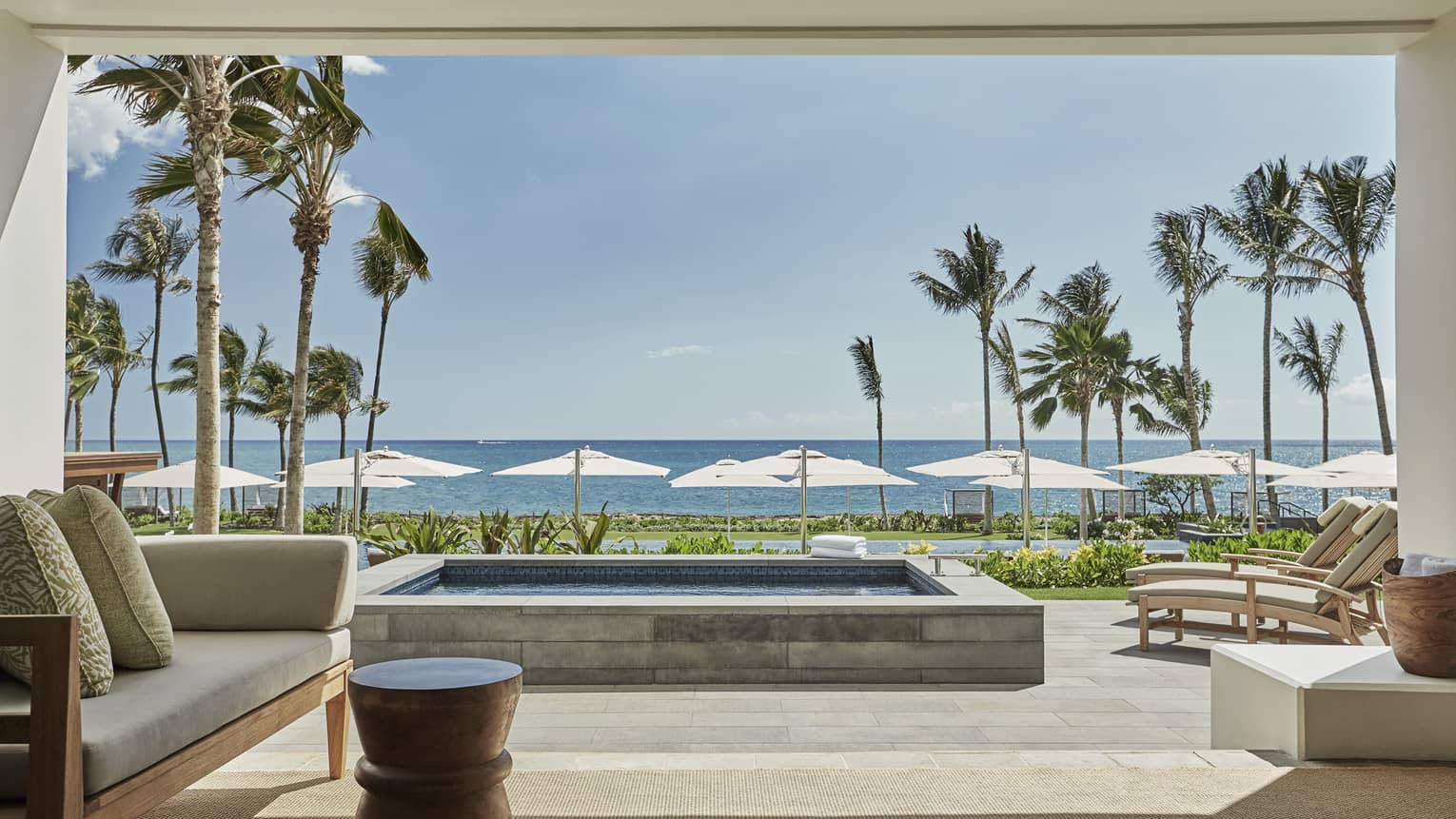 Pacific Suite open to wall to patio with stone plunge pool, lounge chairs, ocean views