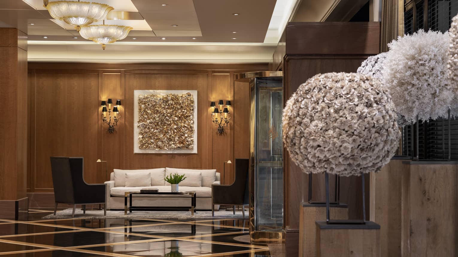 FS Boston lobby with gold wall decor, wall sconces, bouquets of white flowers