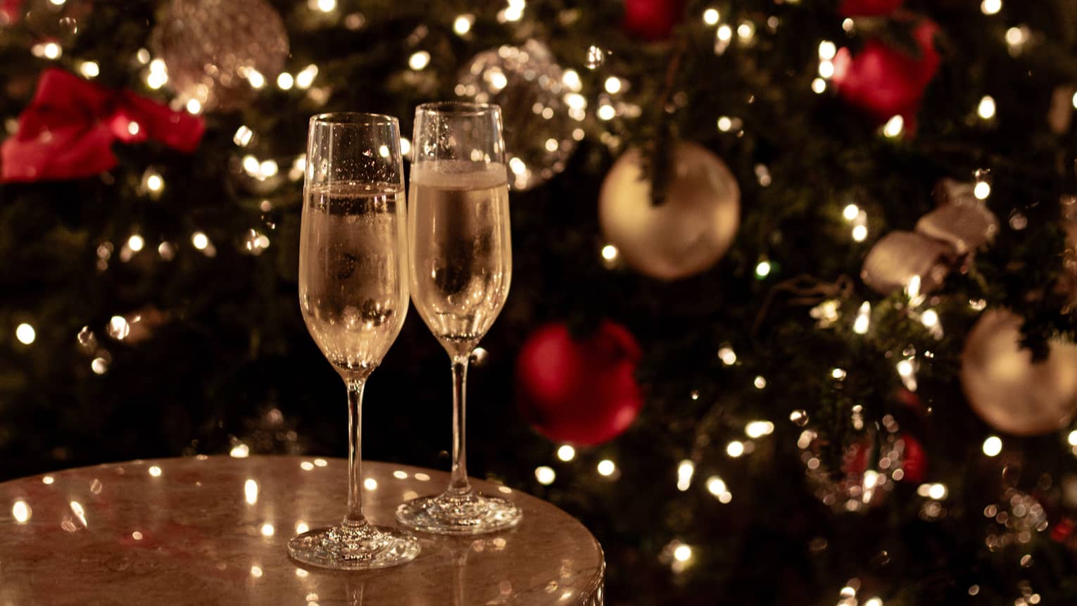Joyous champagne toast with festive lights for Tokyo Christmas and New Year’s Eve celebrations.