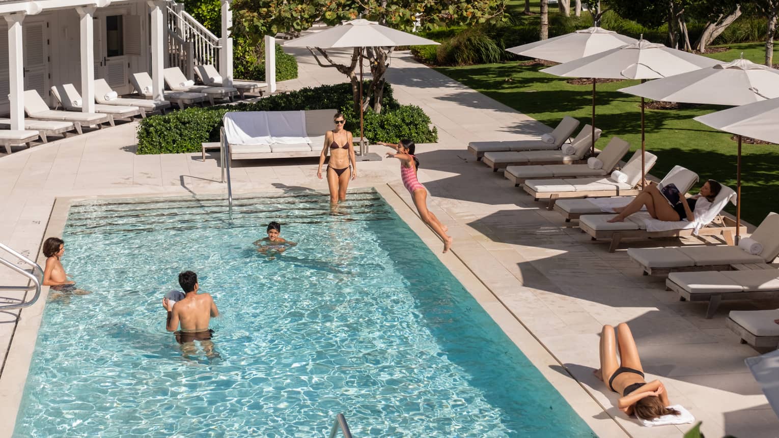 Guests lounge in and around a hotel pool