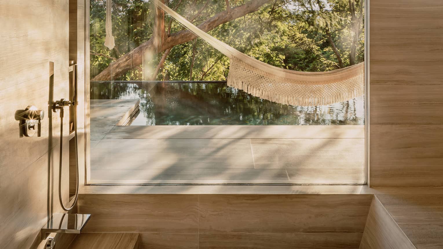Sunken tub with window / wall opening to a private terrace with hammock and plunge pool