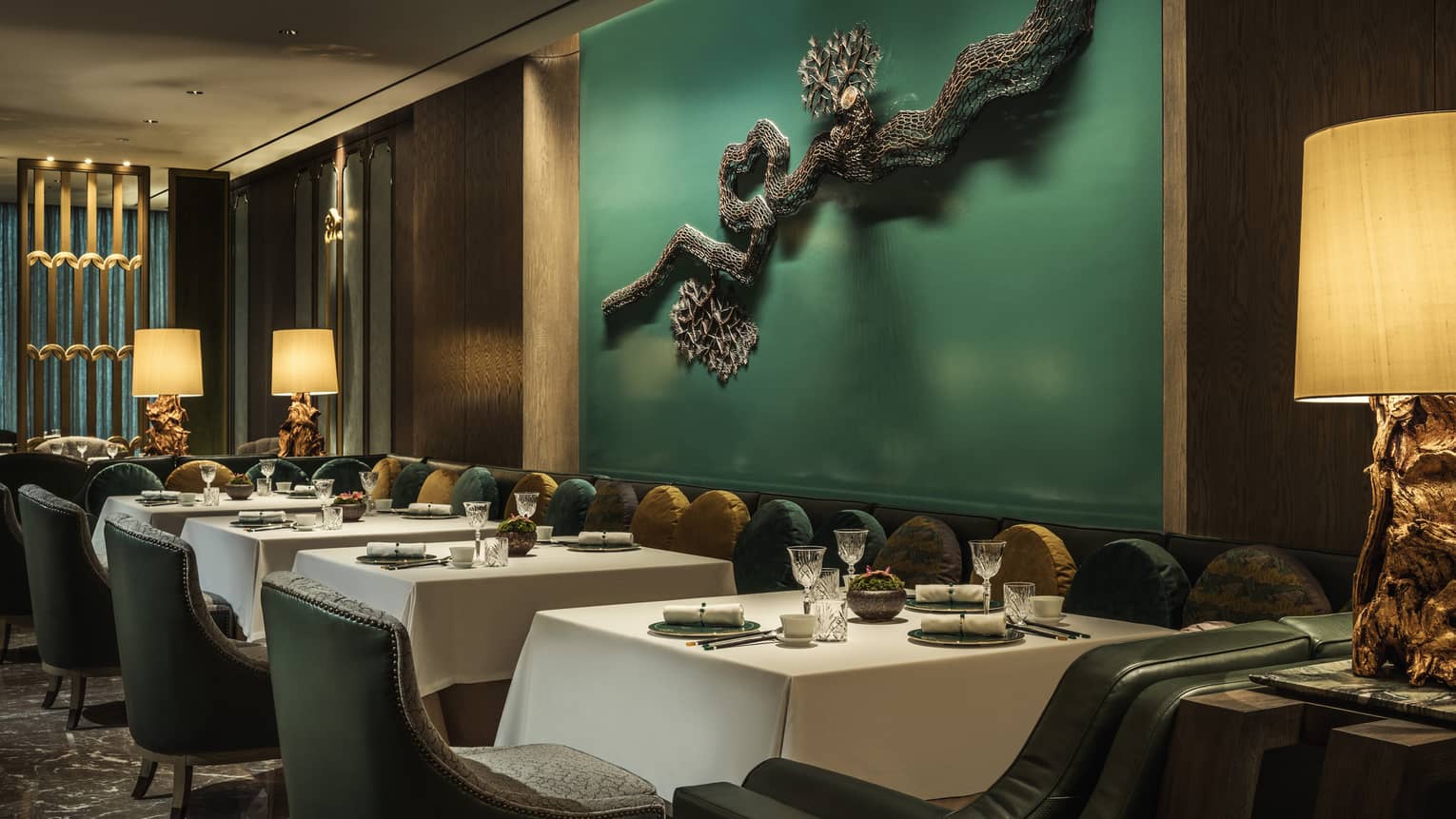 Yu Yuan dining tables, chairs under green wall with modern wire sculpture