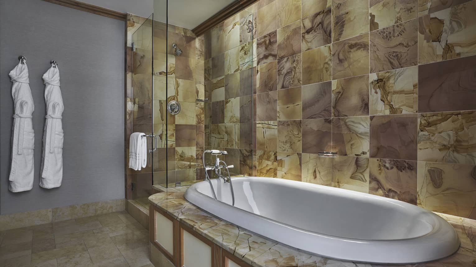 Tiled bathroom with a soaking tub and separate glass-enclosed shower