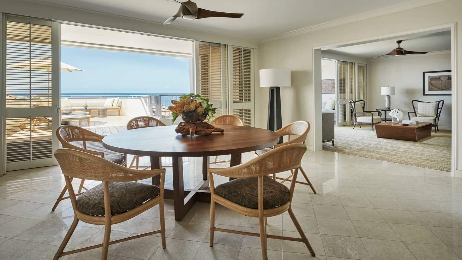 Residence dining room with round wood table retro wicker seats, sliding balcony shutters