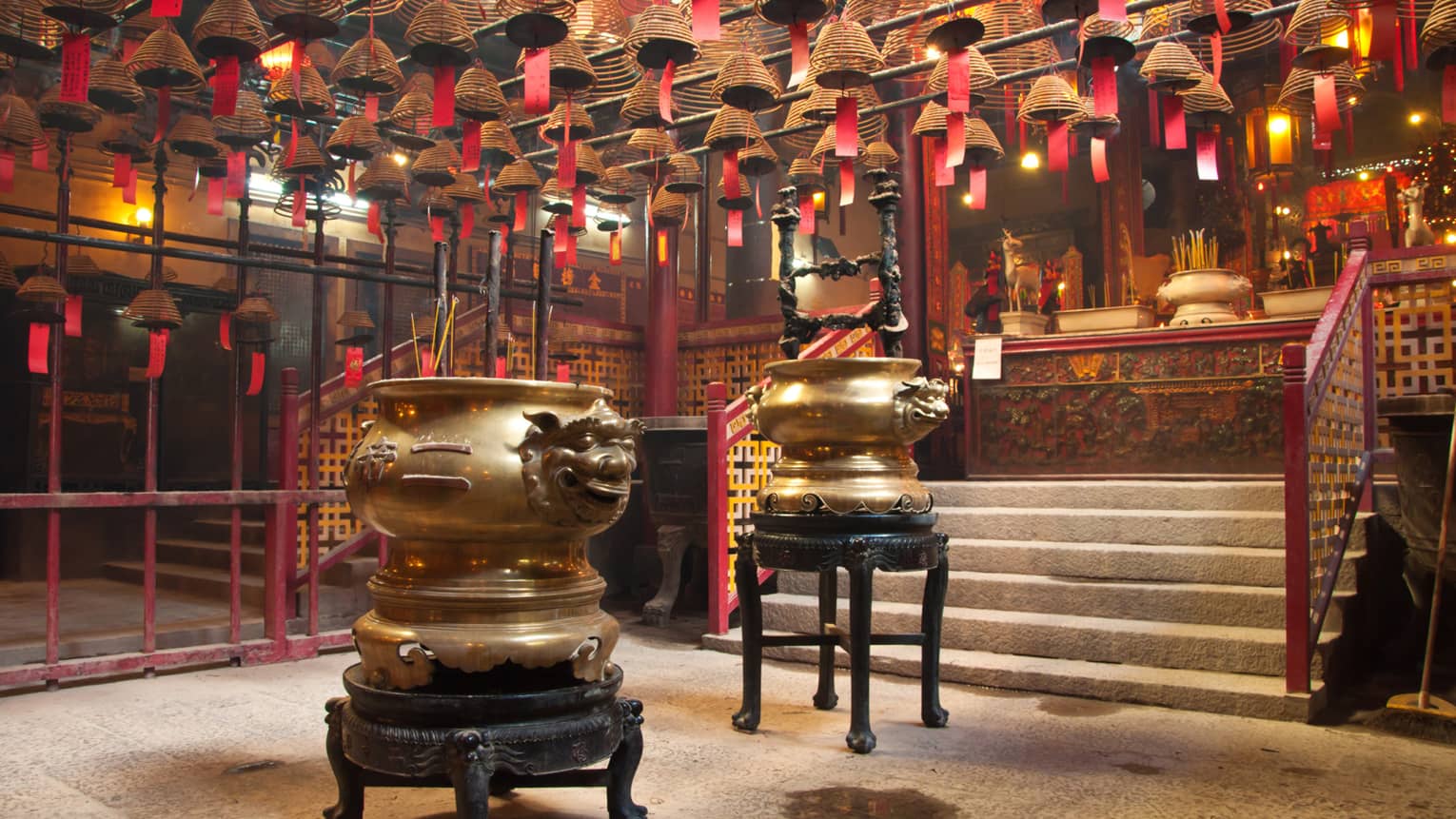 Man Mo temple interior, featuring red and bronze hanging light fixtures