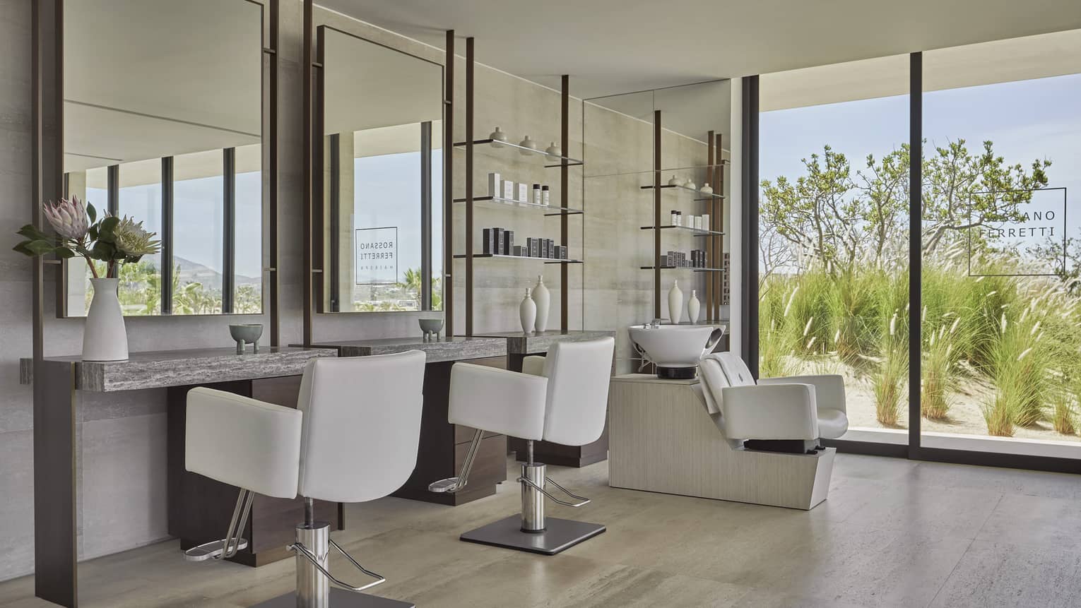 Salon and massage chairs in a brightly lit room near mirrors.