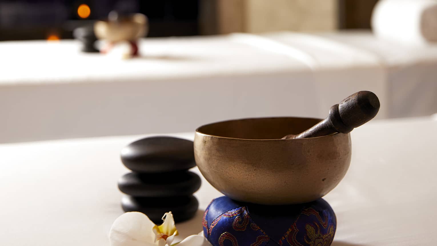 Copper bowl and wood spoon on couples spa treatment beds in spa