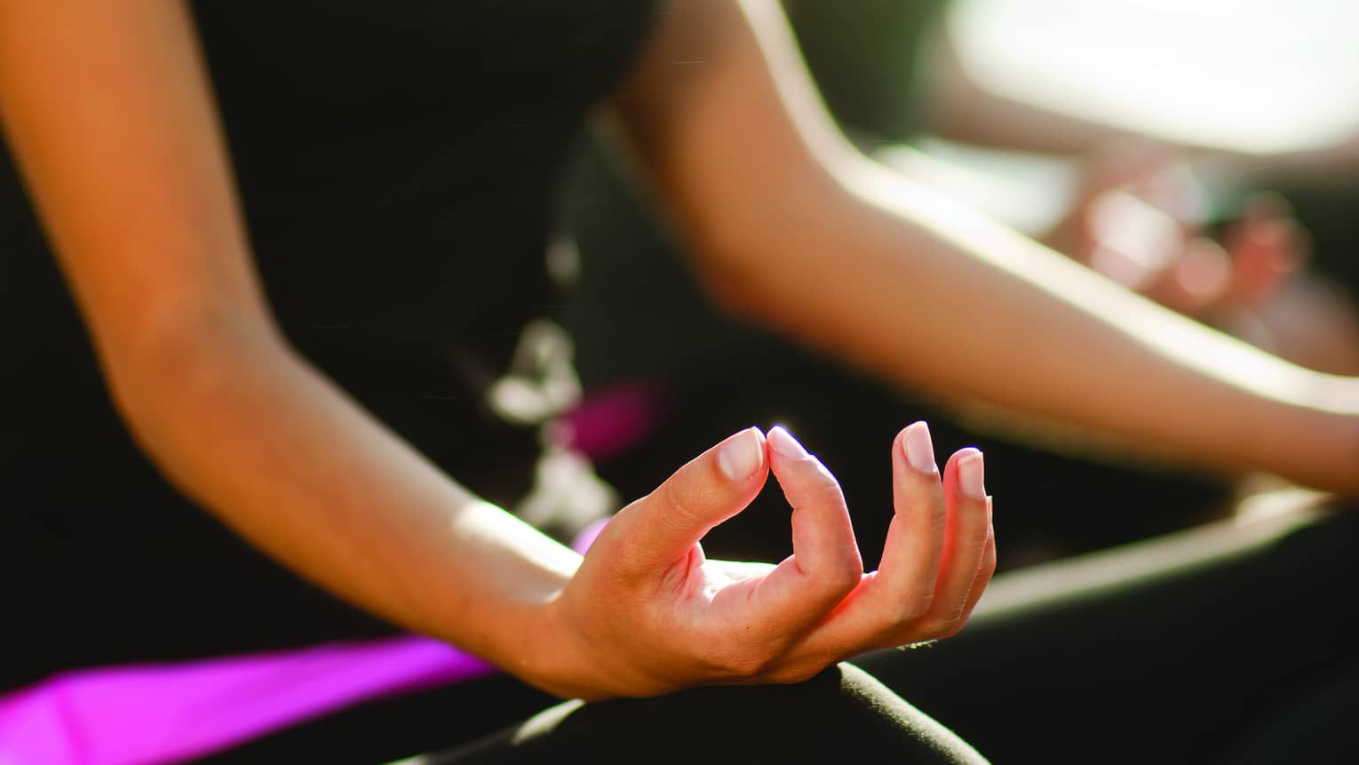 Two women sitting in a yoga pose.