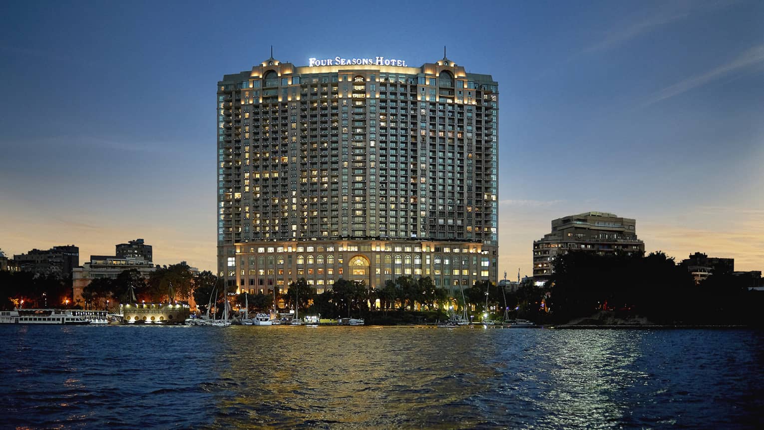 Hotel exterior illuminated at dusk, along the Nile River
