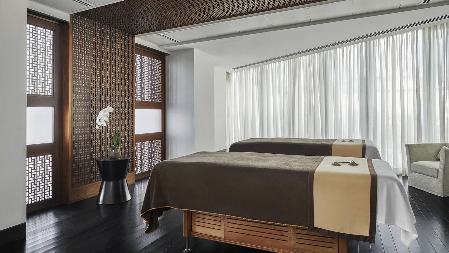 Pearl Spa side by side couples massage beds in treatment room with wood accent walls