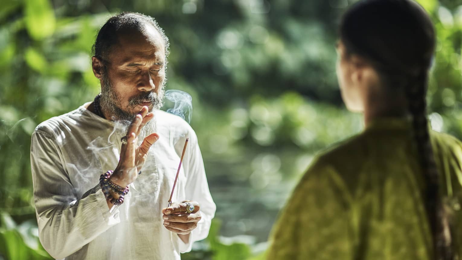 A healer holding a burning stick of incense  