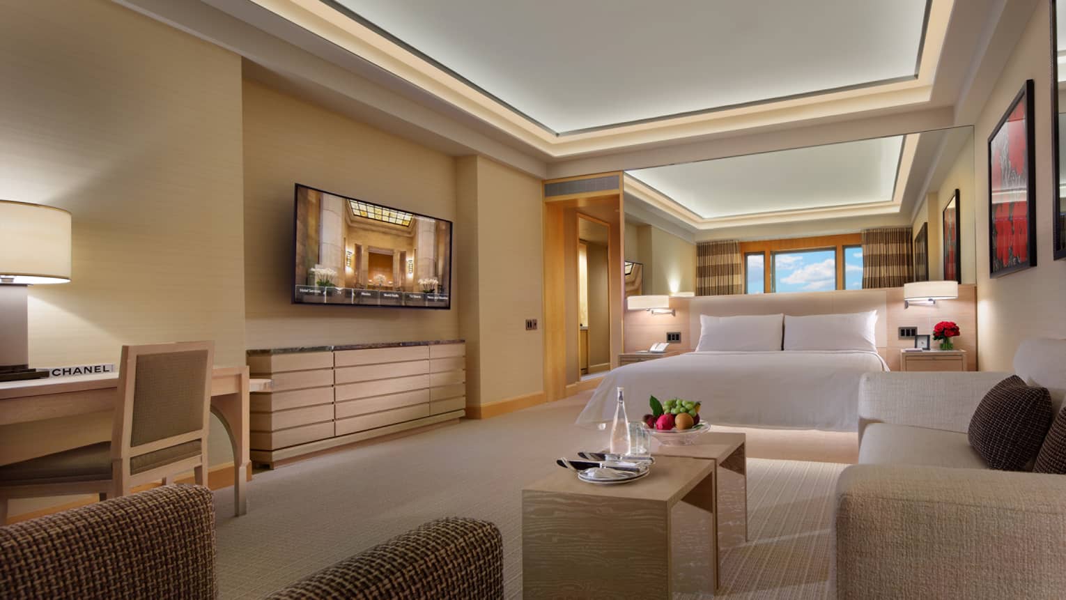 Cosmopolitan Junior Suite modern room with cream-and-white decor, large TV, mirror wall above bed