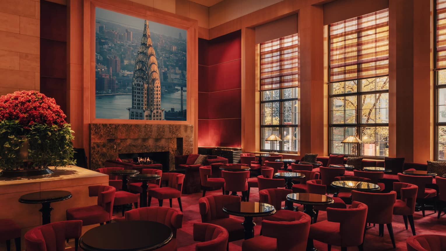 A spacious yet cozy lounge interior with upholstered seating, large windows and artistic decor