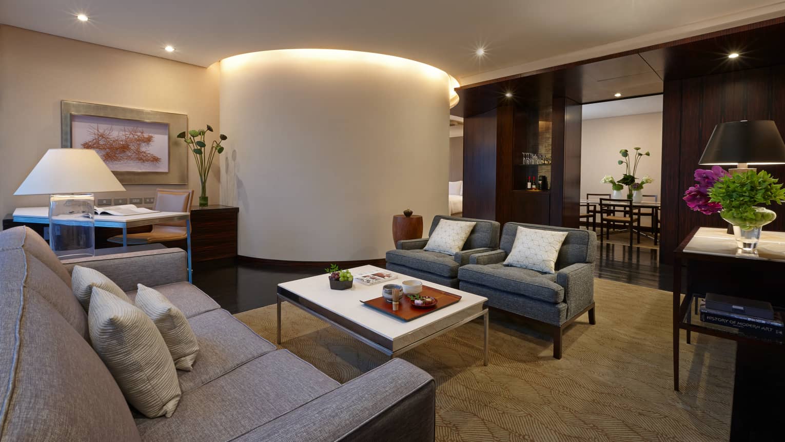 Deluxe Suite grey sofas by large curved white pillar with lights