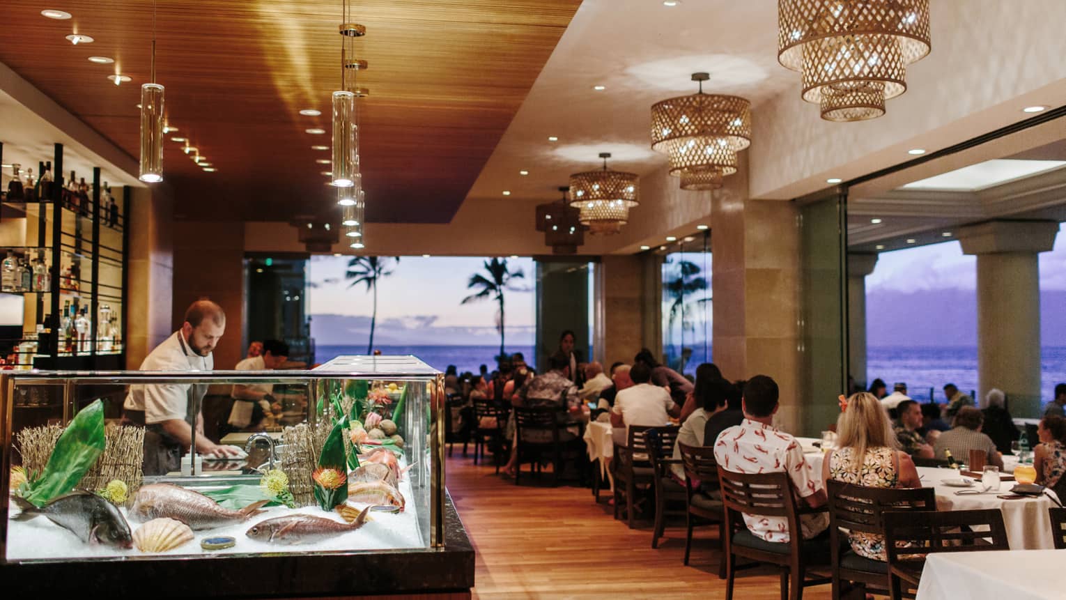 A view of Spago restaurant at Four Seasons Resort Maui at Wailea, with the ocean surrounding it at sunset