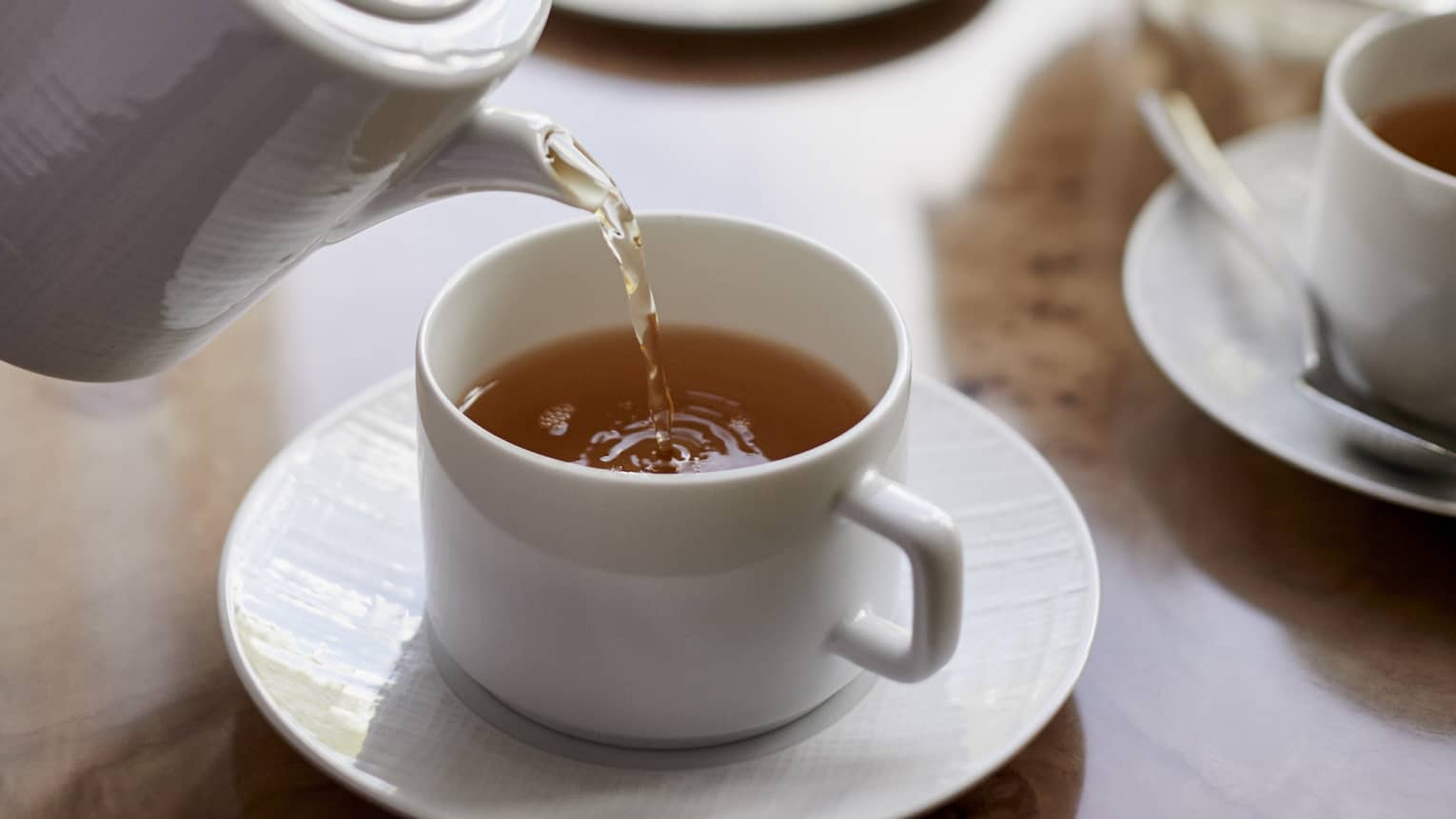 Close-up of tea being poured into white cup