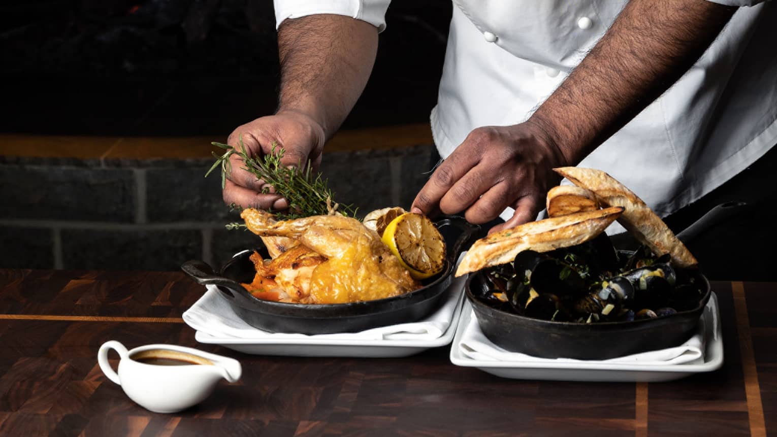 Chef arranging chicken dish in a cast-iron skillet