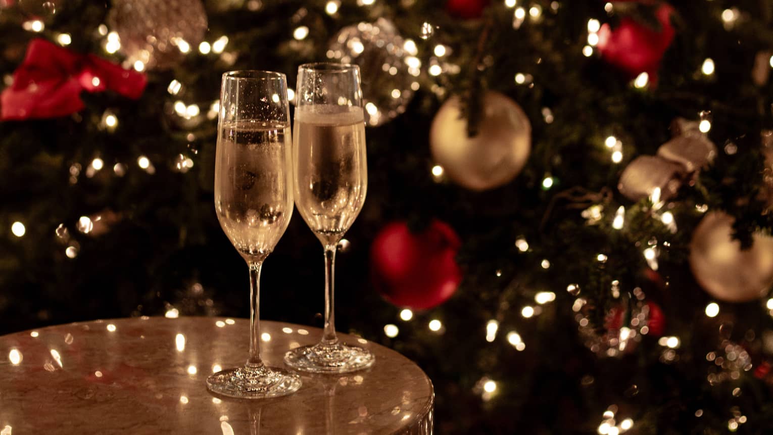 Joyous champagne toast with festive lights for Tokyo Christmas and New Year’s Eve celebrations.