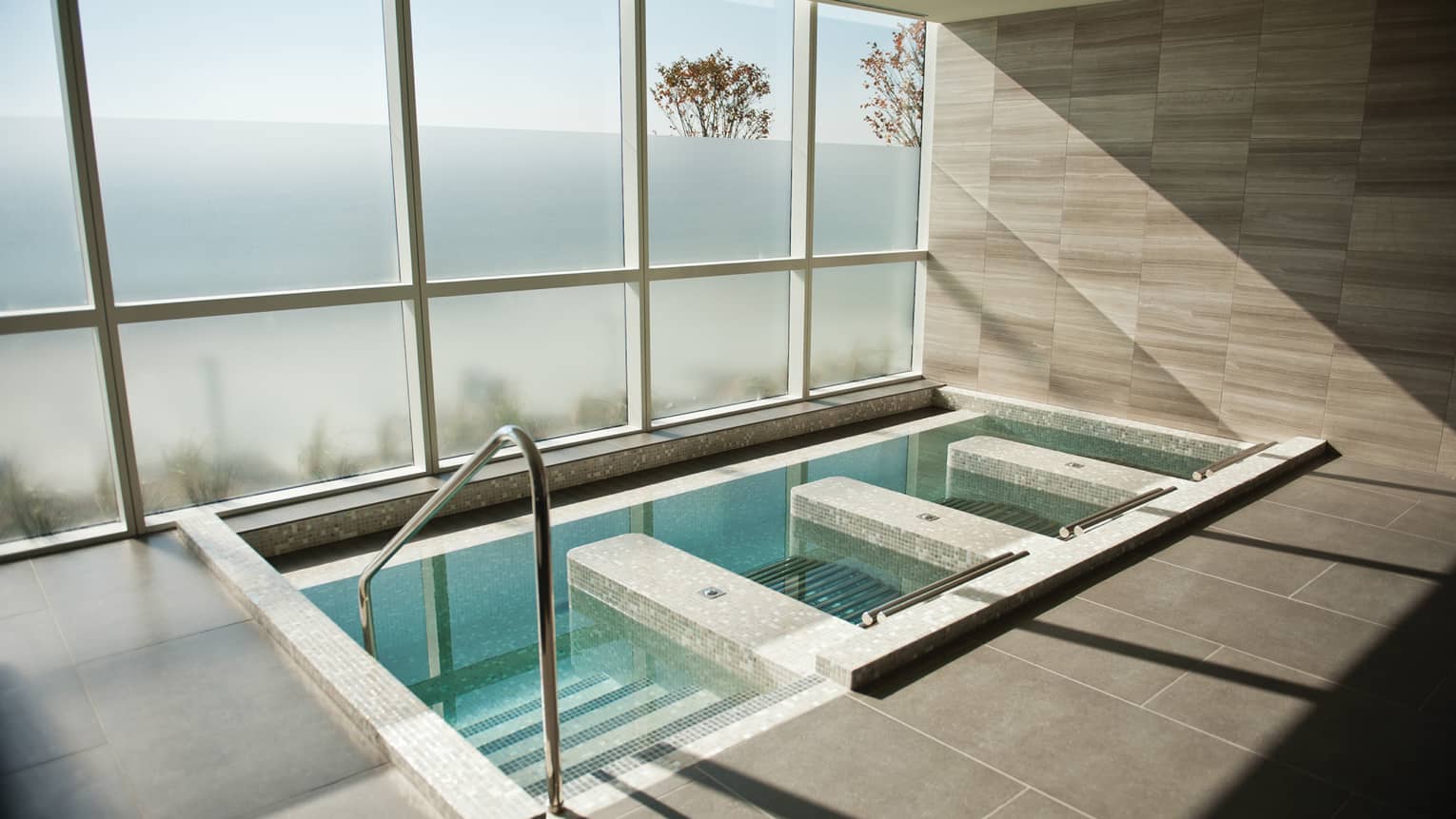 Steps down into tile spa plunge pool, tub under large window