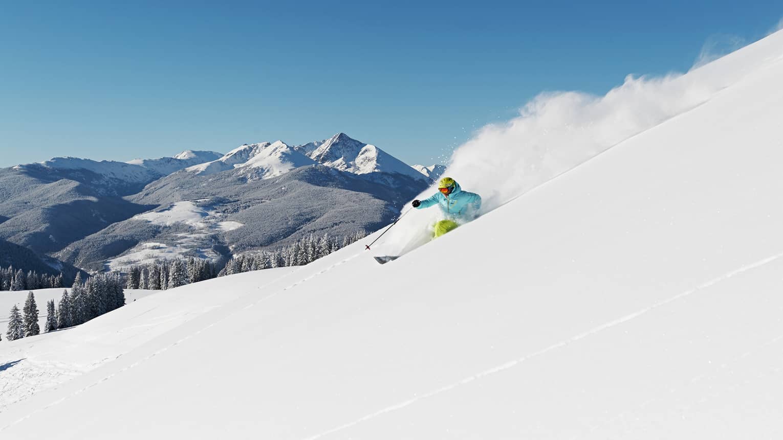 Person skiing down snow covered mountain top