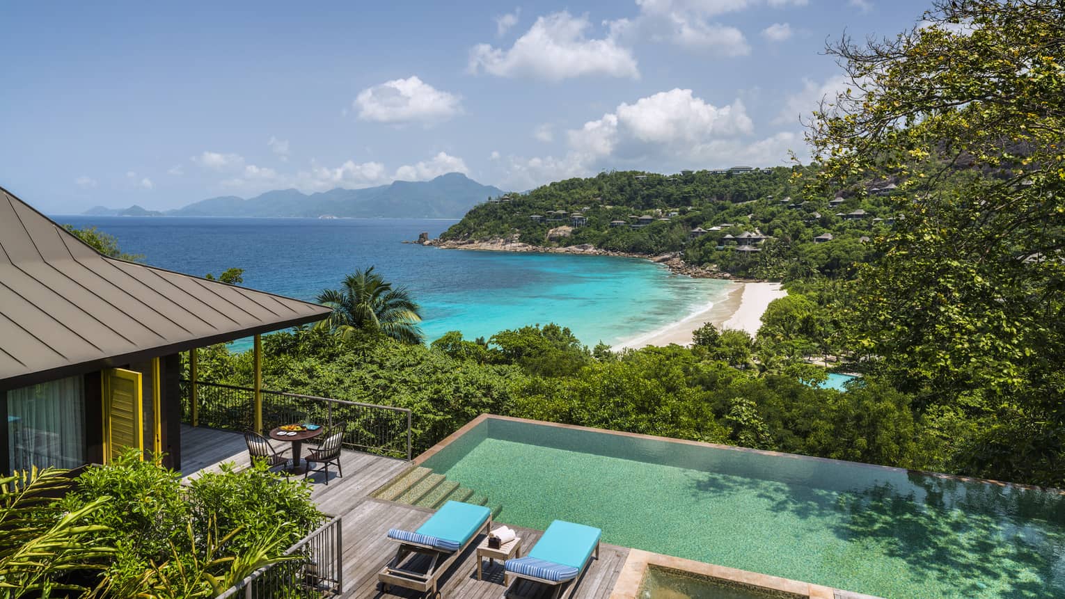 Aerial view of Two-Bedroom Ocean-View Suite pool, chairs and deck, mountain and ocean views