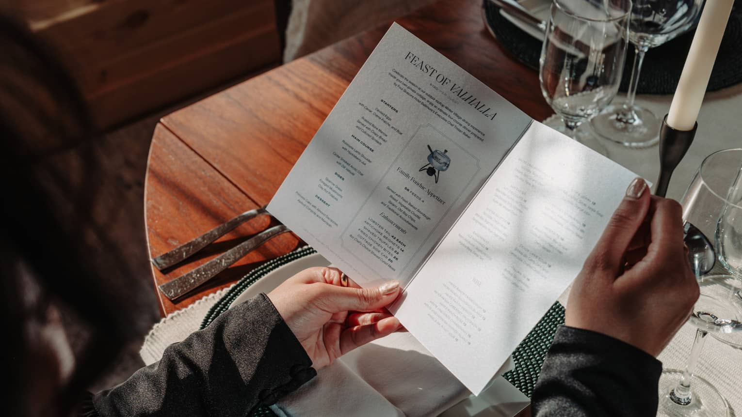 Person sitting at a dining table and reading a folded menu