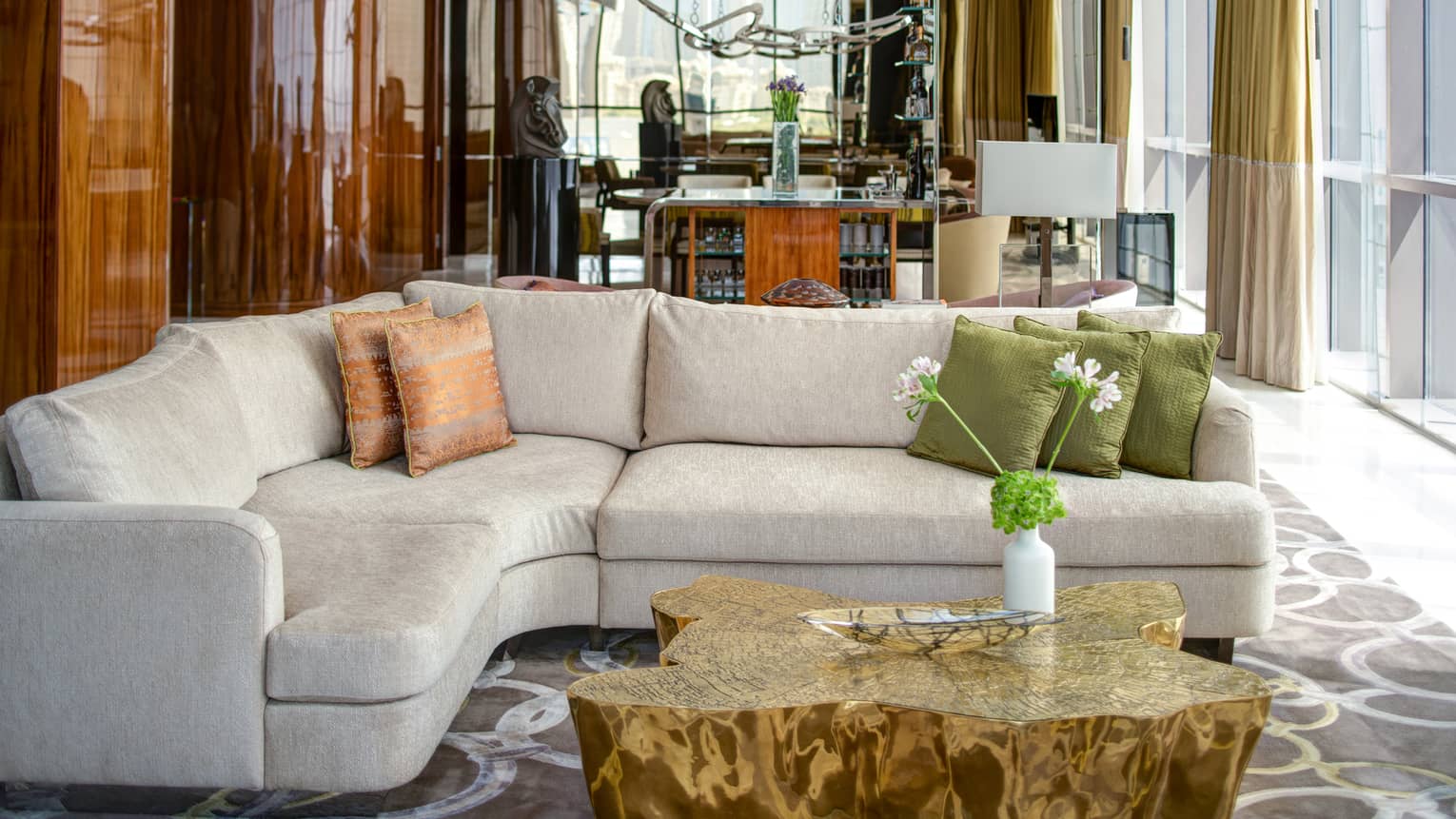 Cream-coloured l-shaped sofa and artistic wooden coffee table