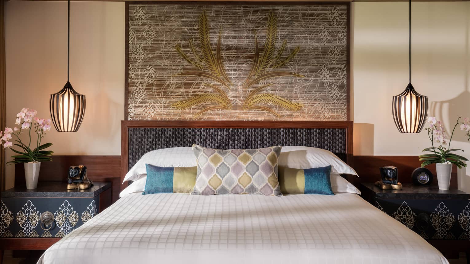 Upper Garden Pavilion room bed with blue-and-green accent pillows, large art, reading lights