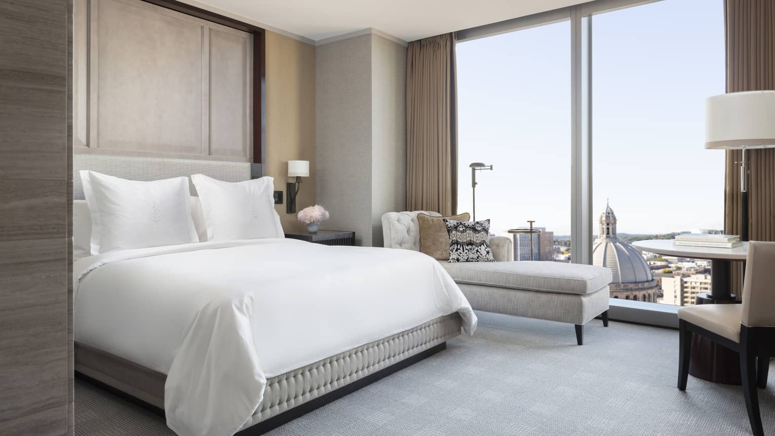The Deluxe Room with a View offers a sleek bed, chaise lounge and floor-to-ceiling windows 