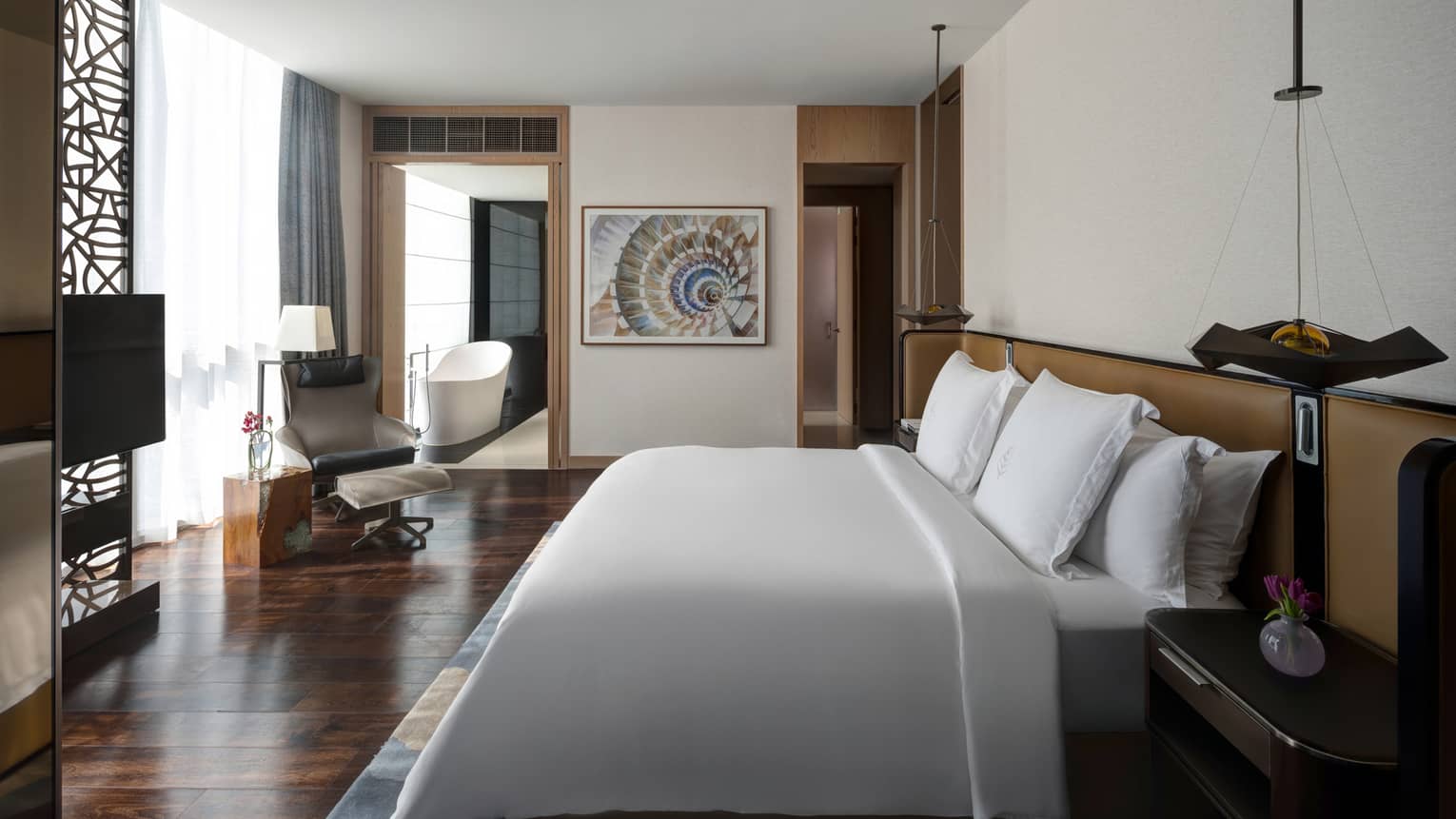 Bedroom with king bed, wooden floors, hanging sconces