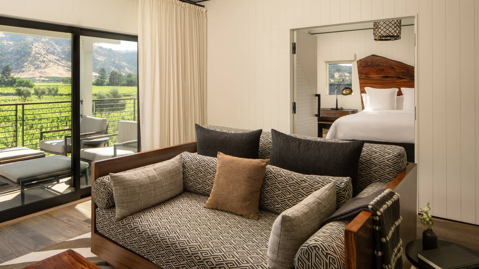 Living room of a resort one-bedroom suite, featuring a sofa and walk-out terrace with vineyard views