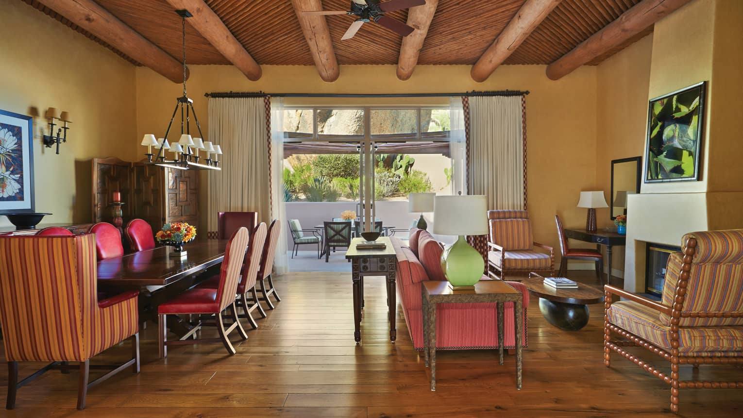 Two-Bedroom Suite long private dining table, living room under wood beam roof, hardwood floors