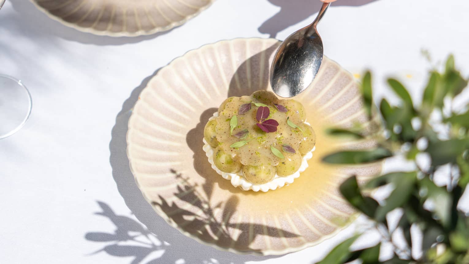 Two people partake of elegant desserts on artistic scallop-edged plates.