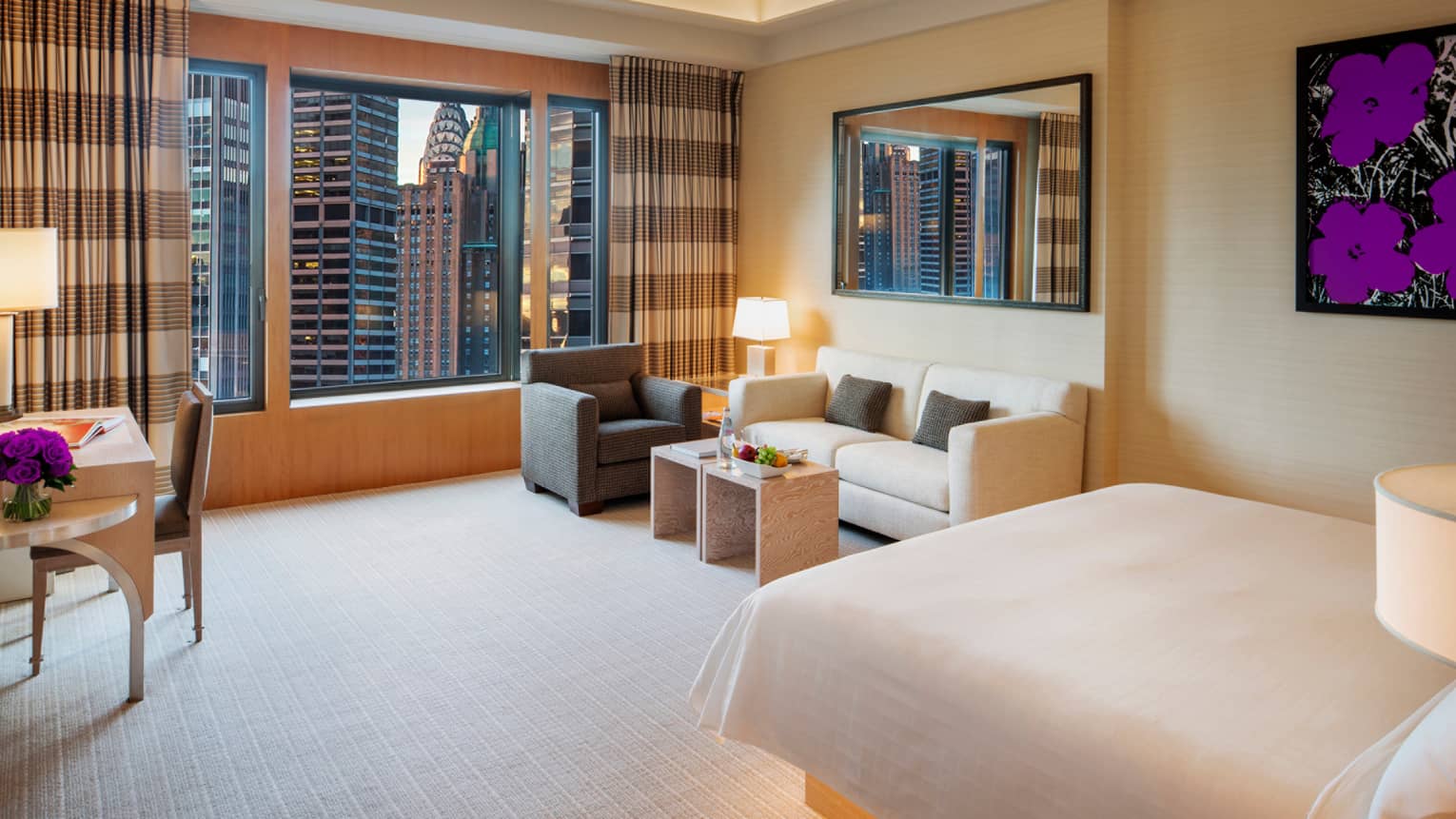 Manhattan Junior Suite bed with illuminated base, small sofa and armchair in corner by large window