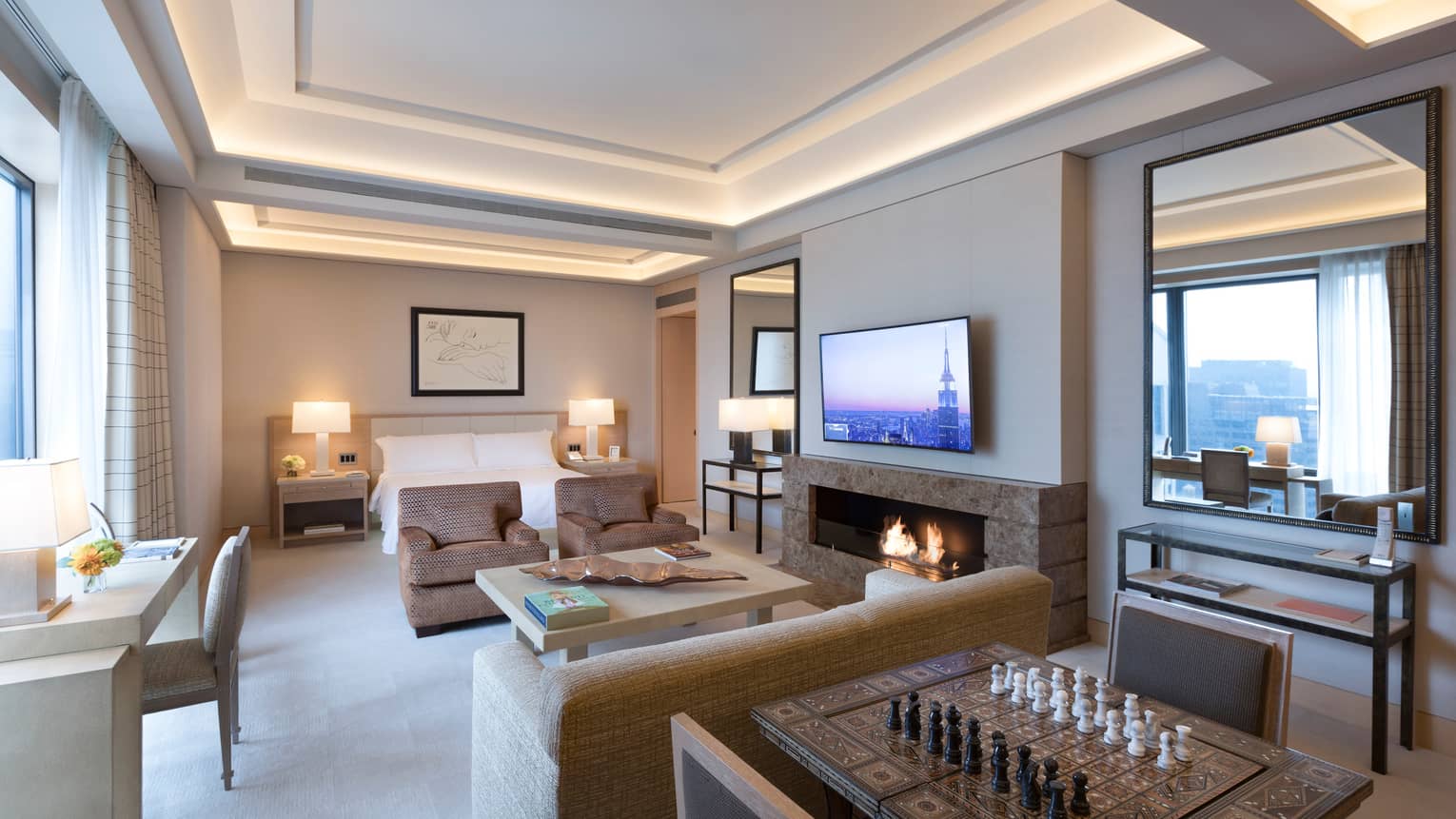 Gotham Suite table with chess board, seating area by fireplace and bed, desk at window
