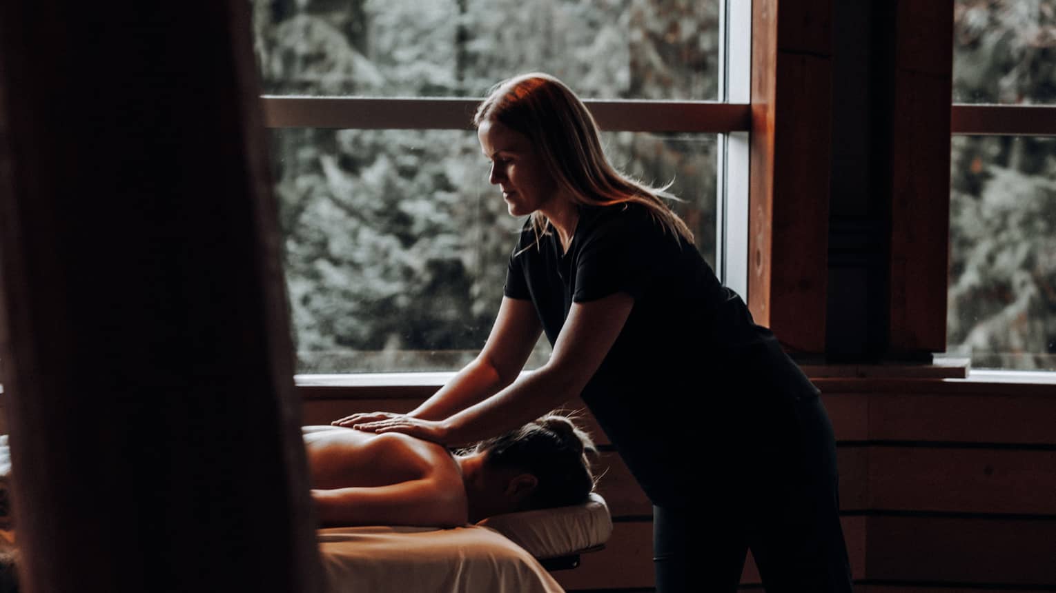 A woman receicing a massage in a dimly lit room.